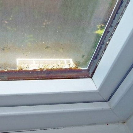 Water in a window with a bad seal caused rust within the pane 